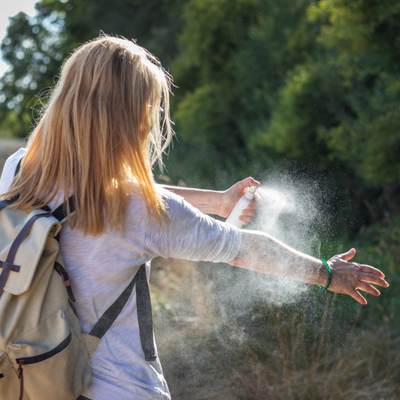 woman spraying bug spray on 
